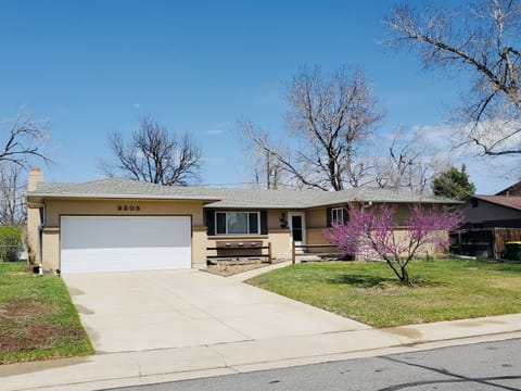 Beautifully landscaped front exterior with a large driveway and garage with private parking access. 