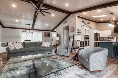 Open concept living room with 65" Roku TV; books, games, sliding door to deck