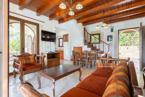 Open-plan living room with sofa, dining area, kitchen, ornamental fireplace, WiFi internet, satellite TV, DVD player, and pool terrace access