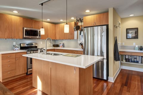 Fully outfitted kitchen with quartz counters and SS appliances.