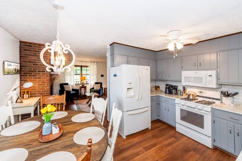 View of the fully equipped kitchen and dining table that seats 6 looking into the living room