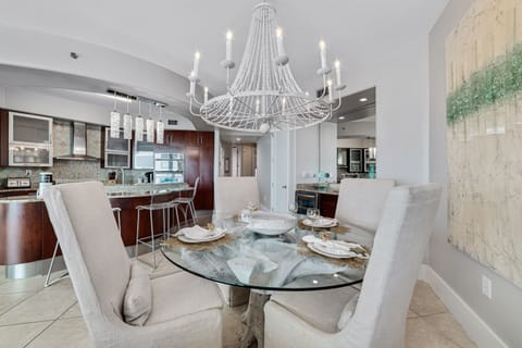 The dining table is set for four with additional seating at the kitchen bar