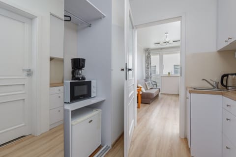 A compact kitchenette with modern white cabinets and a convenient layout for cooking.