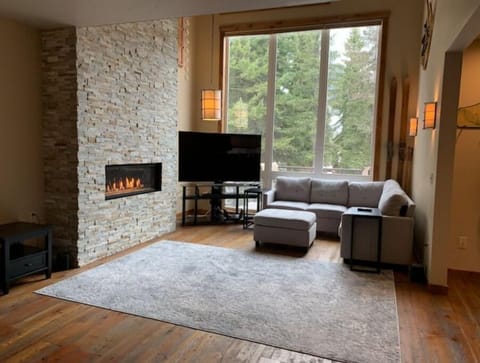 This luxe living room boasts a cozy fireplace and picturesque views.