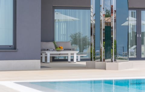 Seating set with a wooden table on the outdoor terrace of the luxury villa Nimai Luce in Istria