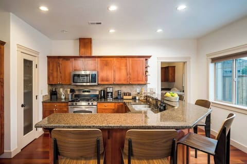 Wrapping around the kitchen is an eat-in bar with beautiful granite countertops. The bar has 6 barstools, providing ample seating for guests. Perfect spot to sip a glass of wine and chat with your friends while your chef finishes up dinner. 