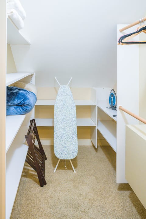 Walk-in closet with iron/board, extra towels and linens