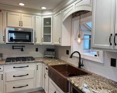 Enjoy the gourmet kitchen with copper sink and gas cooktop with pot filler.