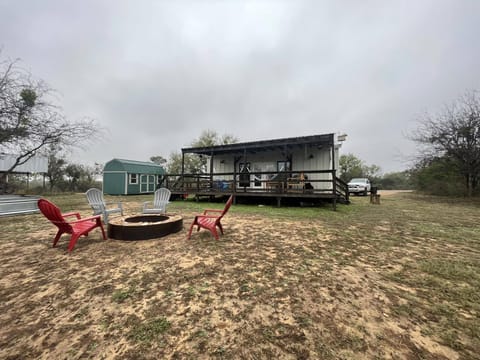 The backyard features a large deck with outdoor seating & 2 hammocks & fire pit.