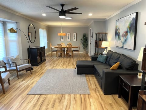 Large living room with plentiful seating, ceiling fan, smart TV.