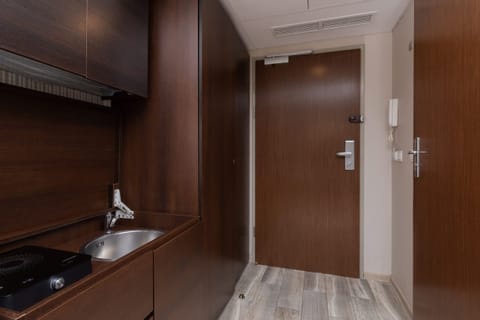 A view of the entryway with wooden finishes and a secure door.
