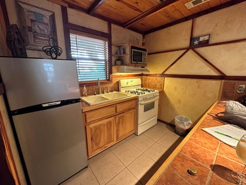 Small kitchenette with stove and fridge. microwave.