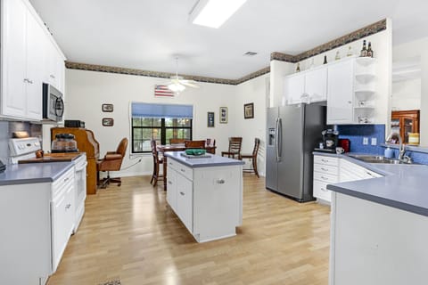 Kitchen is equipped with a refrigerator, microwave, oven, stove, and coffee maker