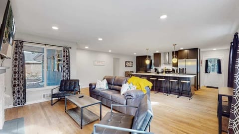 A bright and inviting living space featuring a cozy fireplace, modern decor, and ample seating, perfect for relaxation and entertainment.