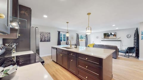 A beautifully designed kitchen with sleek dark cabinetry, stainless steel appliances, and a spacious island, offering both functionality and style.