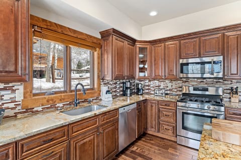 High-end stainless steel appliances, granite countertops, and wood finishes