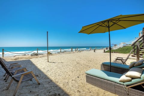 Private beach with lounge seats, chairs, and teatherball