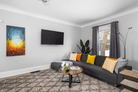 Sectional sofa, flat-screen TV, and colorful art throughout