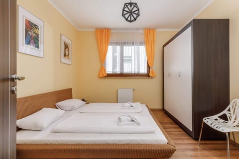 A minimalist bedroom with a comfortable double bed, a wardrobe, and neutral decor for a relaxing atmosphere.