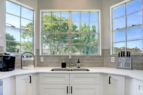 High ceiling kitchen with bay window. Curtains are provided.