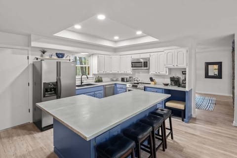 Fully stocked kitchen with stainless appliances, large island, and ample prep space for group meals.