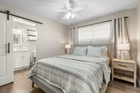 This bedroom with a full bathroom is the perfect place to unwind and relax during your stay. The bedroom features a comfortable queen-sized bed with plush pillows and linens, as well as bedside tables with lamps. 