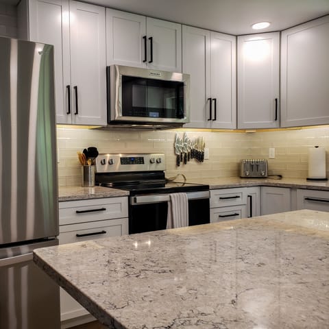 Stainless appliances, quartz countertops and large island with 4 barstools.