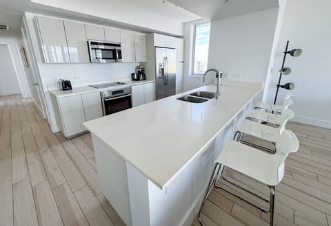 Fully equipped kitchen with stainless steel appliances and a stylish backsplash.