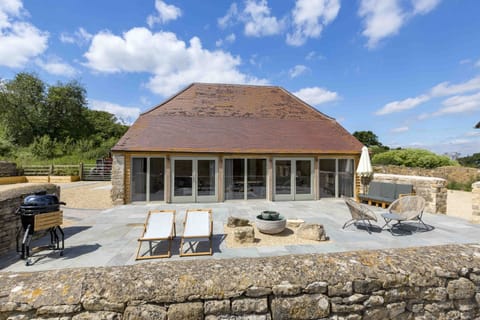 Large patio with chairs, outside sofa bed and charcoal BBQ