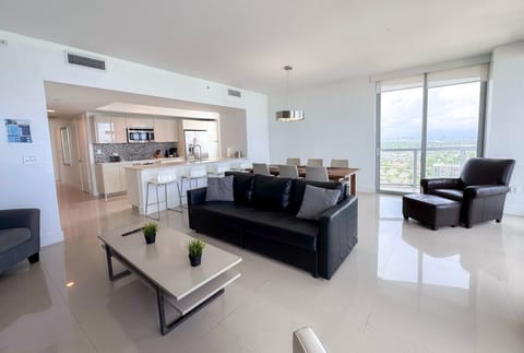 Bright living room with balcony access and city views.