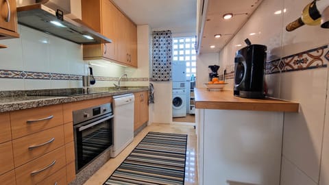 Kitchen and utility room with washing machine and tumble drier, plus dishwasher