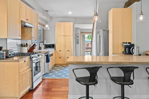 Amazing kitchen with high end Bosch appliances: large refrigerator, gas stove, dishwasher, microwave, air fryer.