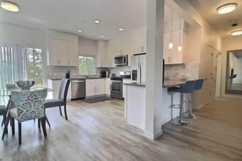 Fully-equipped kitchen with bar seating, dining nook, and patio with olive orchard views.