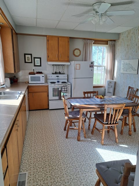 This farmhouse kitchen has lots of dishes & cookware and overlooks the deck/bay.
