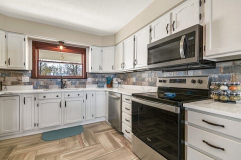 Stocked chef's kitchen with stainless appliances, dishwasher, and coffee bar