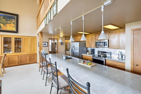 The well-stocked kitchen has a huge island and an ample assortment of dishware, glassware, and flatware.