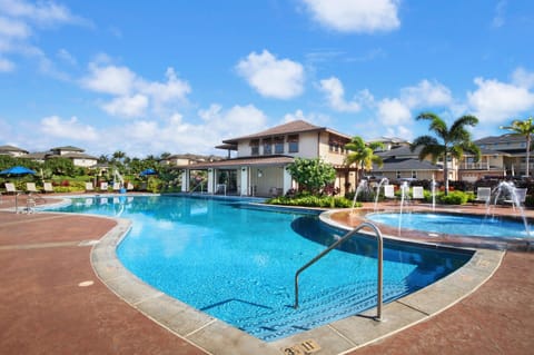 Resort-style pool at Pili Mai with sun loungers and tropical surroundings