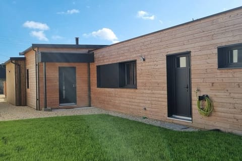 Côté entrée et parking de la maison avec partie engazonnée.