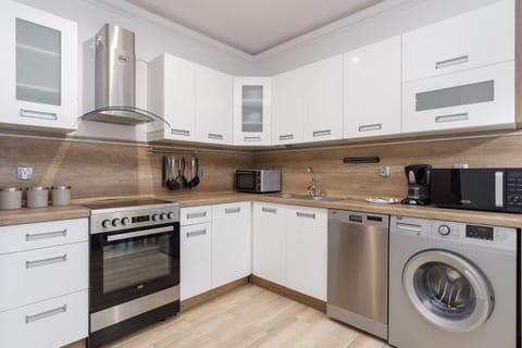 A modern kitchen with white cabinets, built-in appliances.