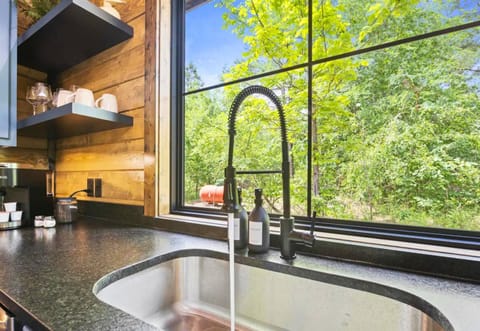 Wash dishes with a view in our cabin's kitchen—where even the chores are a retreat. Gaze out to the greenery and let the calm of nature speed up the scrubbing