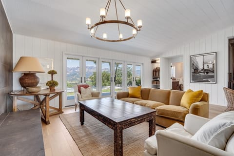 Living room with formal seating and views to the palisades and pool.