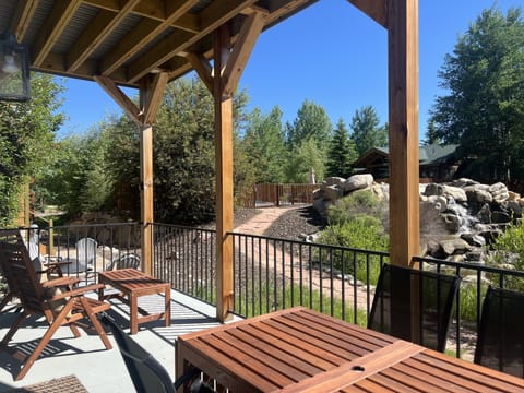 Back deck view towards neighborhood pool & waterfall. Table expands to seat 10