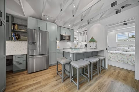 Modern updated kitchen featuring sleek stainless steel appliances, a spacious layout, and a stylish kitchen island with barstool dining—perfect for meals and gathering.