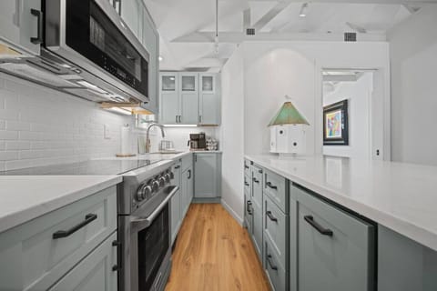 Modern updated kitchen featuring sleek stainless steel appliances, a spacious layout, and a stylish kitchen island with barstool dining—perfect for meals and gathering.