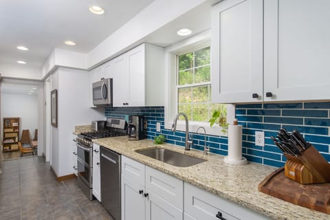 Kitchen with gas range, dishwasher, drip-style coffee maker, and pantry