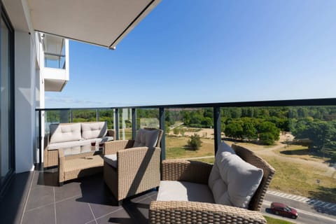 A spacious balcony equipped with outdoor furniture, offering a perfect spot to enjoy the view.