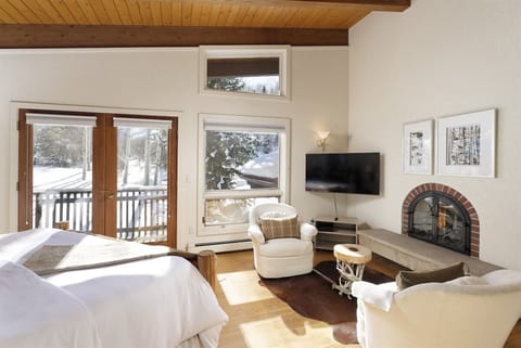 Fourth floor primary suite with gas fireplace, private deck, seating area, and ensuite bathroom.