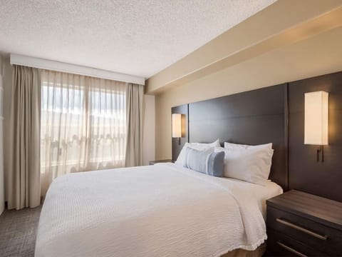 Unwind in a plush king bed beside sunlit windows.