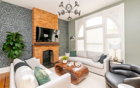 Stylish living room with exposed brick decorative fireplace and 4K TV