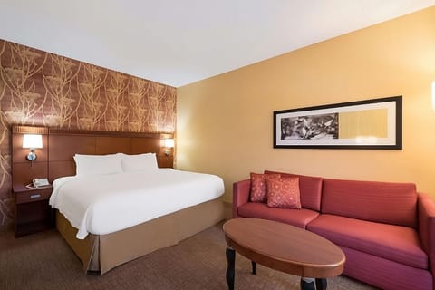 Unwind on the plush king bed beside cozy sofa.